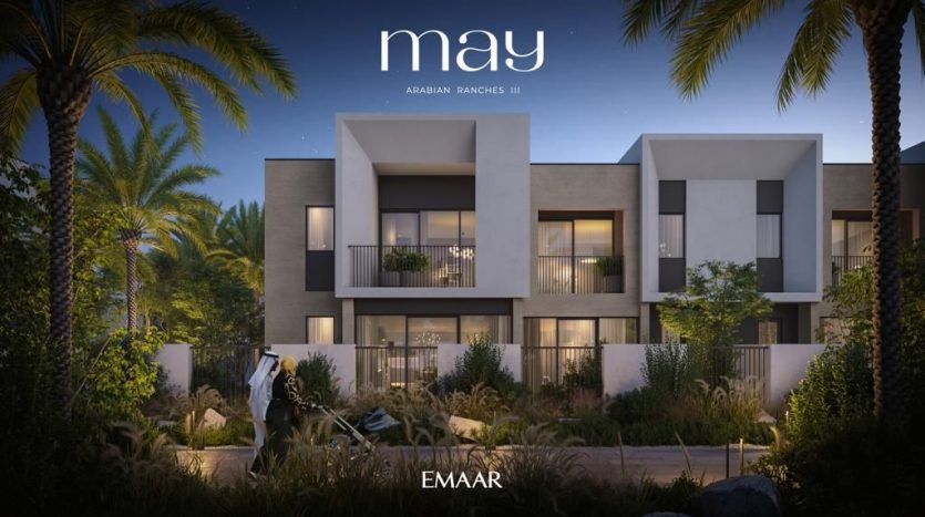 Vue nocturne d&#039;un complexe de villas modernes à Dubaï au design élégant et contemporain, entouré de verdure luxuriante et de palmiers. Une bannière promotionnelle pour &quot;May Arabian Ranches III&quot; par Emaar est
