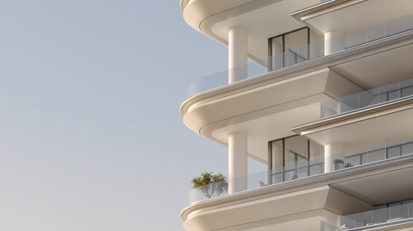 Immeuble d&#039;appartements moderne doté de balcons curvilignes, d&#039;une façade d&#039;un blanc éclatant et de balustrades en verre transparent sur un ciel dégagé au coucher du soleil à Dubaï.