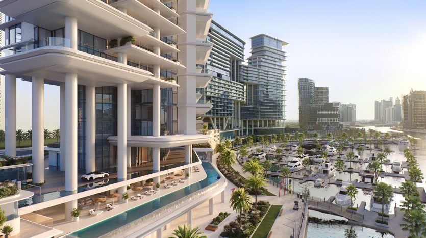 Un développement moderne en bord de mer avec des bâtiments et des appartements luxueux à plusieurs étages donnant sur une marina avec des yachts, entourés de palmiers sous un ciel dégagé.