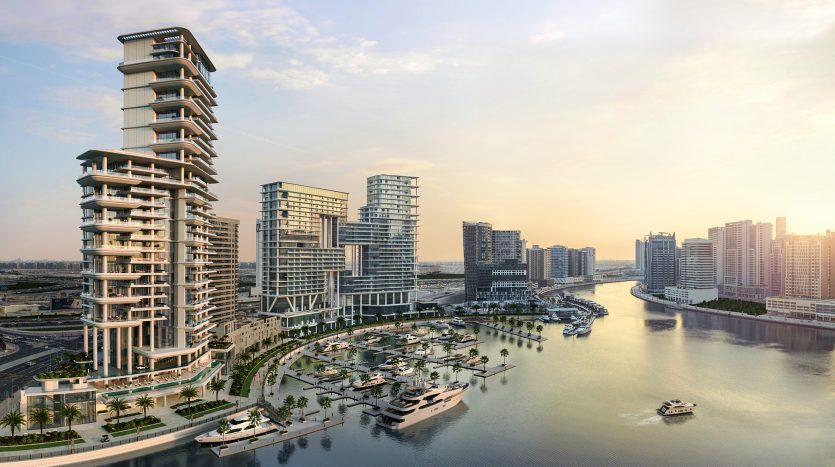 Vue aérienne d&#039;un paysage urbain moderne au bord de l&#039;eau au coucher du soleil à Dubaï, avec une marina, des immeubles de grande hauteur de luxe, des palmiers luxuriants et des bateaux naviguant sur la rivière.