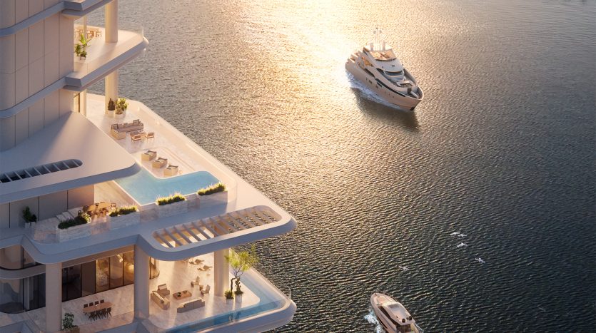 Un immeuble de grande hauteur à Dubaï avec des balcons donnant sur une rivière, avec deux yachts naviguant à proximité, par une journée ensoleillée.