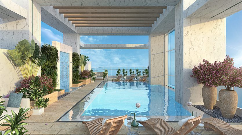 Espace piscine extérieure luxueuse avec chaises longues et pergola aérienne, entourée de grandes jardinières avec des fleurs épanouies, surplombant un paysage côtier pittoresque sous un ciel dégagé dans un appartement exclusif de Dubaï.