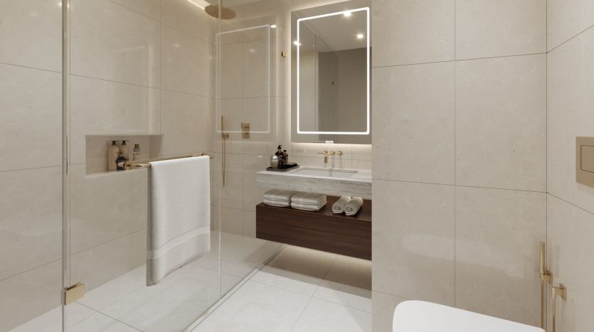 Une salle de bains moderne dans une villa de Dubaï comprenant une douche en verre, un grand miroir au-dessus d&#039;une vanité en bois avec lavabo et des toilettes blanches. Les murs et le sol sont carrelés en beige clair.
