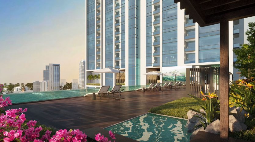 Une luxueuse piscine sur le toit d&#039;un immeuble moderne de grande hauteur à Dubaï, dotée de chaises longues, de plantes luxuriantes et d&#039;une vue sur les toits de la ville sous un ciel dégagé.