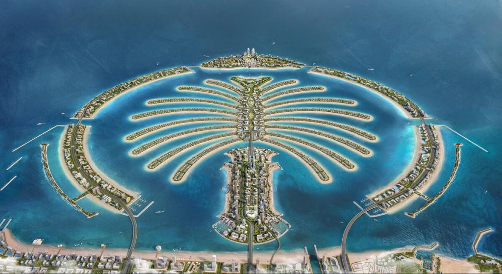 Luftaufnahme von Palm Jumeirah in Dubai, die seine einzigartige Palmenform mit luxuriösen Wohnhäusern und Hotels entlang wedelförmiger Inseln, die von türkisfarbenem Wasser umgeben sind, hervorhebt. Diese renommierte Gegend ist perfekt für Investitionen