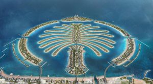 Vue aérienne de Palm Jumeirah à Dubaï, mettant en valeur sa forme unique de palmier avec des résidences et des hôtels luxueux le long d&#039;îles en forme de frondes entourées d&#039;eaux turquoise. Ce quartier renommé est parfait pour investir