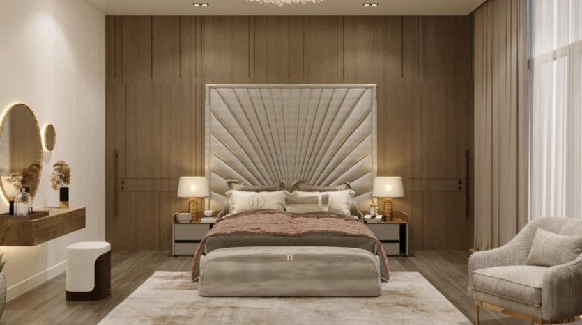Une chambre moderne comprenant un grand lit à oreilles avec une literie beige et grise, des murs en panneaux de bois, des tables de chevet symétriques avec lampes, une chaise moelleuse et un tapis moelleux présenté par une agence.