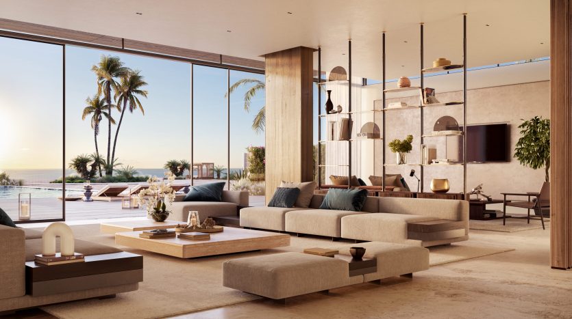 Intérieur luxueux d'un salon d'appartement à Dubaï avec de grandes fenêtres en verre offrant une vue sur une piscine et des palmiers au coucher du soleil. La pièce est meublée de canapés élégants, d'une table basse et d'un éclairage moderne.