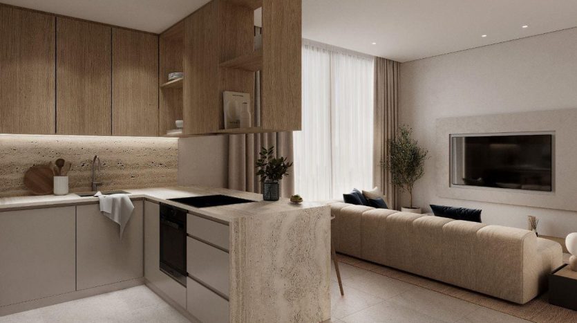 Une cuisine et un salon modernes et minimalistes avec des armoires en bois, des appareils électroménagers intégrés, un long canapé beige, du carrelage et une grande fenêtre avec des rideaux transparents dans une villa de Dubaï.