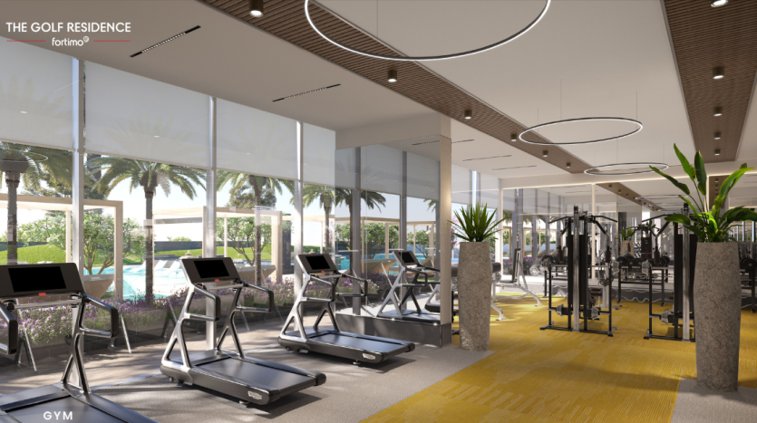 Une salle de sport moderne avec des tapis roulants face à de grandes fenêtres donnant sur une piscine et des palmiers. L&#039;intérieur présente des accents en bois, des lumières circulaires et un tapis jaune vif dans une villa de premier ordre à Dubaï.