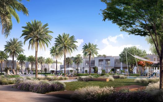 Une communauté résidentielle moderne de Dubaï comprenant des bâtiments blancs de faible hauteur entourés de palmiers luxuriants, des jardins paysagers avec des fleurs violettes et une aire de jeux, sous un ciel bleu clair.