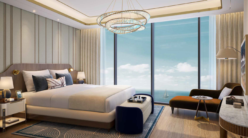 Chambre d&#039;hôtel luxueuse dotée d&#039;un grand lit, d&#039;une décoration moderne avec des accents dorés et bleus, de baies vitrées révélant une vue sur l&#039;océan et d&#039;un lustre élégant dans un emplacement privilégié de Dubaï.