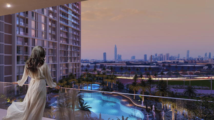 Une femme vêtue d&#039;une robe longue se tient sur le balcon d&#039;un appartement de Dubaï au crépuscule, surplombant un paysage urbain avec des gratte-ciel et une piscine éclairée en contrebas, reflétant le ciel rose du soir.