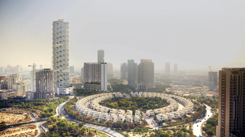 Vue aérienne d&#039;un paysage urbain présentant des structures résidentielles circulaires entourées de routes courbes, avec des immeubles modernes de grande hauteur en arrière-plan sous un ciel brumeux à Dubaï.