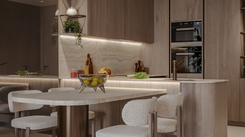 Une cuisine moderne dans un appartement de Dubaï aux tons neutres avec un dosseret en marbre intégré, des armoires en bois, un îlot central avec des tabourets de bar et un luminaire suspendu élégant.