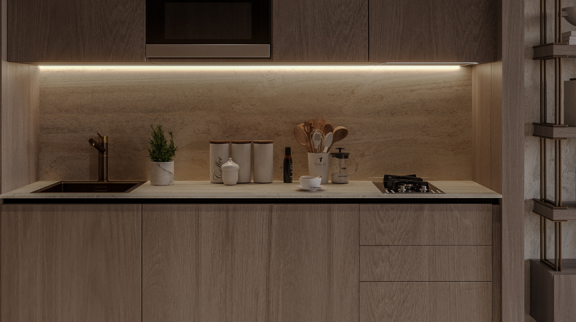 Un comptoir de cuisine moderne éclairé par un éclairage sous les armoires, présentant des appareils électroménagers élégants, une cuisinière, des ustensiles dans un support et de petites plantes en pot, sur fond d'armoires et d'étagères en bois
