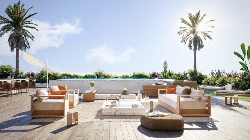 Luxueuse terrasse extérieure dans une villa à Dubaï, avec des meubles modernes en bois, des coussins orange moelleux, une cheminée centrale et entourée d'une verdure luxuriante et de palmiers sous un ciel bleu clair.