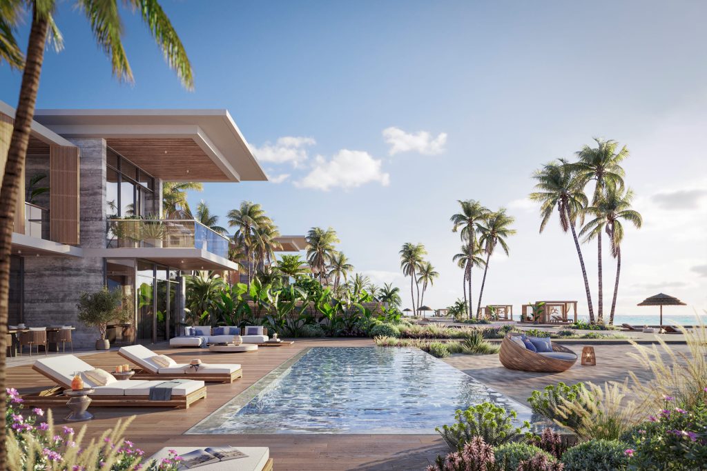 Un luxueux complexe tropical doté d'une grande piscine entourée de palmiers, de chaises longues, d'une végétation luxuriante et de villas modernes en bord de mer avec vue sur l'océan, parfait pour ceux qui s'intéressent à l'immobilier Dubaï.