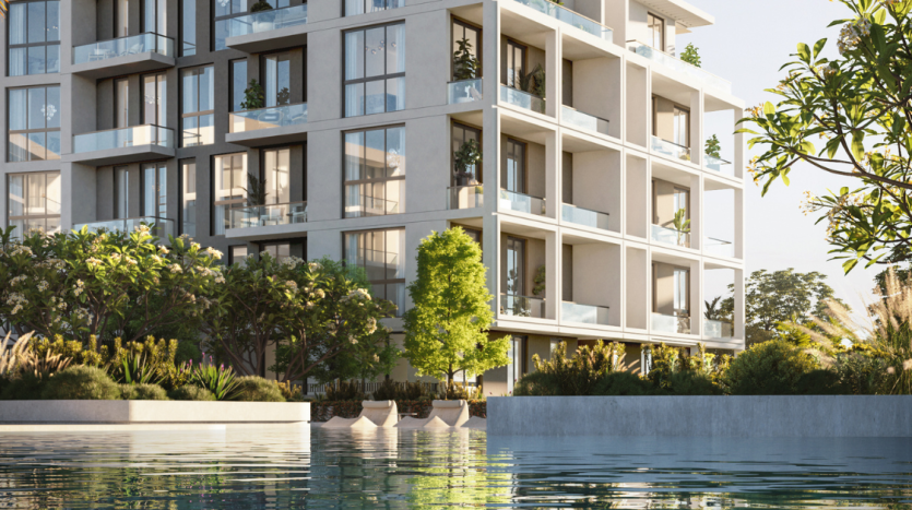 Immeuble d&#039;appartements moderne à Dubaï avec de spacieux balcons sur une piscine réfléchissante, entouré d&#039;une verdure luxuriante, représentant un environnement de vie urbain serein.