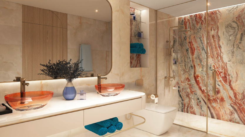 Une salle de bains luxueuse dans une villa à Dubaï comprenant un meuble-lavabo double avec des bols en verre rouge, des murs et des accents en marbre, une douche vitrée et des serviettes bleues. Les plantes décoratives ajoutent une touche