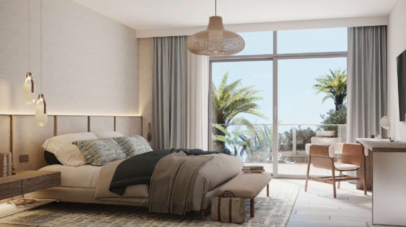 Intérieur de chambre moderne avec un lit confortable, un mobilier contemporain, des lampes suspendues et une grande fenêtre offrant une vue sur les palmiers et le ciel clair de Dubaï.