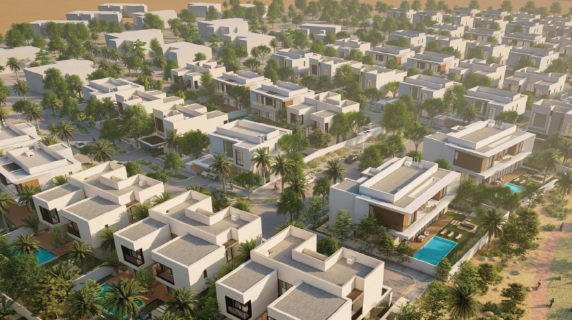 Vue aérienne d&#039;un quartier résidentiel moderne de Dubaï avec des maisons blanches cubiques entourées de palmiers et quelques maisons dotées de piscines privées, dans un cadre désertique au coucher du soleil.
