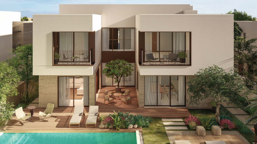 Villa moderne à Dubaï avec des murs blancs, de grandes fenêtres en verre et des balcons donnant sur une piscine entourée de terrasses en bois et ombragée par des arbres.