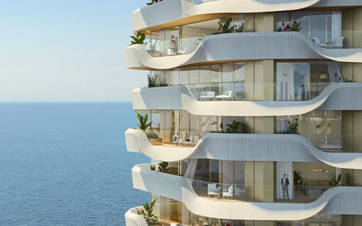 Immeuble moderne de plusieurs étages en bord de mer à Dubaï avec des balcons ondulés, des plantes luxuriantes et des personnes profitant de la vue.