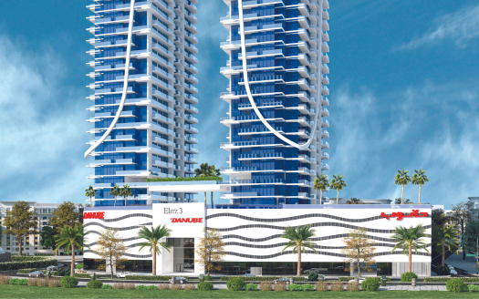 Un immeuble résidentiel moderne de grande hauteur avec des balcons blancs incurvés compensés par du verre bleu sous un ciel clair, entouré d'un aménagement paysager vert et doté d'une *agence immobilière Dubaï* à la base