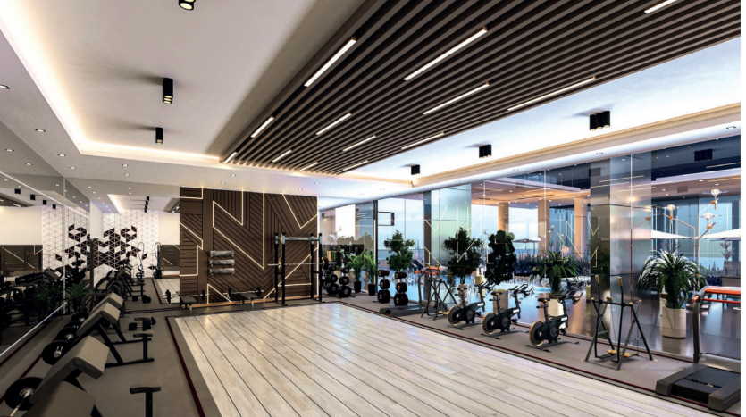 Une salle de sport moderne avec de grandes fenêtres, du parquet et des lattes de plafond. Il comporte des rangées d'équipements d'exercice comme des tapis roulants et des vélos, et des plantes vertes rehaussent l'ambiance de cette villa à Dubaï.