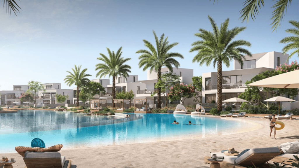 Un complexe luxueux à Dubaï avec des bâtiments blancs modernes, des palmiers luxuriants et une grande piscine. Les gens se détendent sur des chaises longues sous des parasols et profitent d&#039;une journée ensoleillée.