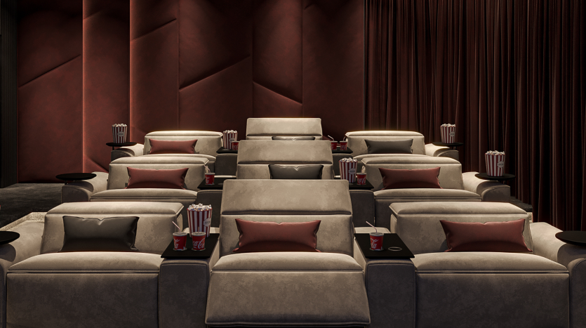 Luxueuse salle de cinéma privée dans un prestigieux appartement de Dubaï, dotée de fauteuils gris moelleux, chacun équipé d&#039;une table d&#039;appoint contenant du pop-corn et des boissons, sur fond de rideaux rouge foncé et