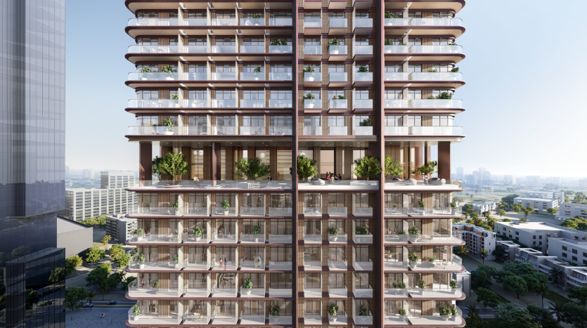Un bâtiment moderne de plusieurs étages doté de grands balcons avec des plantes vertes luxuriantes, situé dans un paysage urbain avec d&#039;autres immeubles de grande hauteur et un ciel bleu clair à Dubaï.