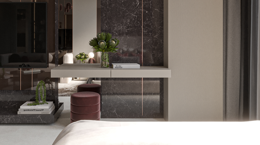 Une chambre moderne dans un luxueux appartement de Dubaï présentant un design élégant avec des murs en marbre, une étagère flottante blanche avec des livres et des plantes, un miroir rond et des tabourets rouges dans un petit coin bureau. Une peluche
