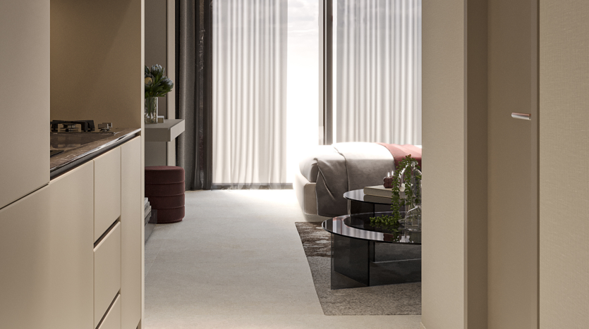 Un salon moderne avec un canapé crème, une table basse en verre et des plantes luxuriantes, vu depuis une cuisine avec des armoires en bois clair. La lumière naturelle filtre à travers des rideaux transparents dans cette villa de Dubaï.