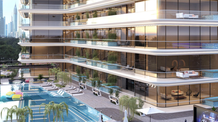 Un immeuble luxueux de grande hauteur avec des balcons en terrasse donnant sur une piscine avec des chaises longues et des cabanes, sur fond de gratte-ciel de la ville au crépuscule à Dubaï.