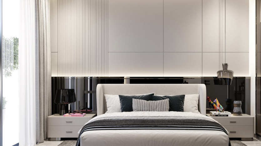 Une chambre moderne dans un appartement de Dubaï avec un grand lit double flanqué de tables de chevet et une élégante armoire murale intégrée. La chambre présente une palette de couleurs douces et des éléments de design contemporain.