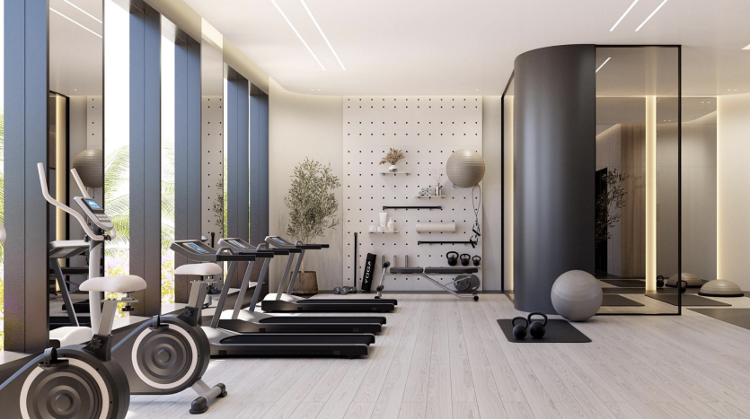 Une salle de sport moderne à domicile dans une villa à Dubaï avec des tapis roulants, des vélos d&#039;exercice, un espace de musculation et de grandes fenêtres donnant sur la verdure. L&#039;espace dispose de parquet et d&#039;un design élégant et minimaliste