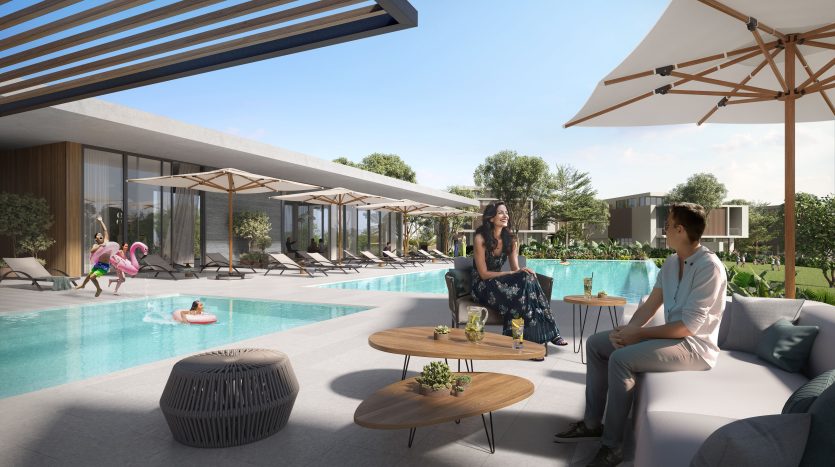 Une scène luxueuse au bord de la piscine dans une propriété exclusive de l&#039;immobilier Dubaï, mettant en vedette une femme et un homme assis et discutant. Chaises longues, parasols et autres personnes profitant de la journée ensoleillée en arrière-plan