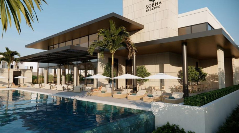 Espace luxueux au bord de la piscine de la réserve Sobha à Dubaï, comprenant des chaises longues sous des parasols, des plantes paysagères et une piscine bleu clair reflétant le ciel.