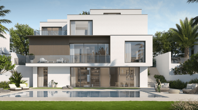 Une maison blanche moderne à deux étages avec de grandes fenêtres, un balcon et un toit-terrasse, entourée de palmiers au bord d&#039;une piscine bleu clair, répertoriée par une agence immobilière de Dubaï.