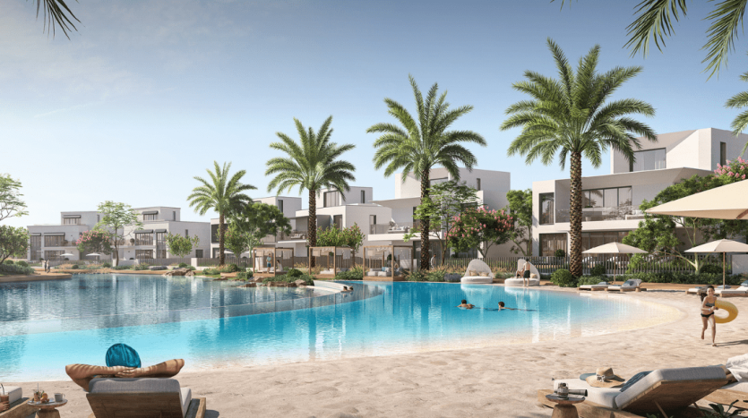 Un complexe luxueux avec des bâtiments blancs modernes entourés de palmiers au bord d&#039;une grande piscine incurvée avec des bordures de sable. Les gens se détendent sur des chaises longues et nagent près d’une superbe villa à Dubaï.