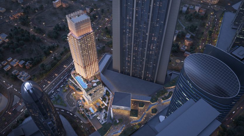 Vue aérienne d&#039;une ville moderne au crépuscule, mettant en valeur des gratte-ciel illuminés, des rues animées et une diversité architecturale, avec un grand bâtiment remarquable au centre, parfait pour les opportunités d&#039;investissement à Dubaï.