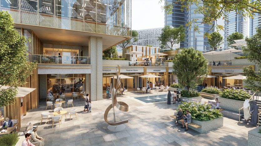 Un centre commercial extérieur animé à Dubaï avec une architecture moderne comprenant plusieurs niveaux, des terrasses bordées de boutiques et de cafés, des gens qui se mélangent et une sculpture artistique près d&#039;une petite piscine.
