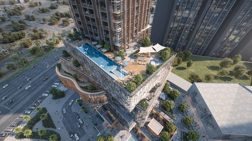 Vue aérienne d&#039;un complexe architectural moderne à Dubaï comprenant un bâtiment avec une piscine sur le toit, des espaces paysagers et des routes environnantes.