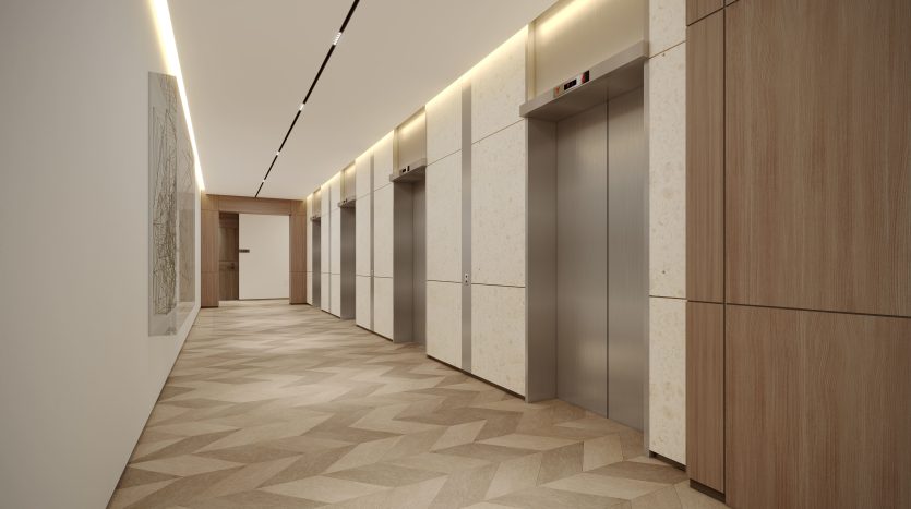Intérieur moderne d&#039;un couloir d&#039;immeuble à Dubaï comprenant deux portes d&#039;ascenseur, des murs lambrissés, des sections en marbre élégantes et un sol à motifs géométriques. Un éclairage décoratif illumine le couloir.