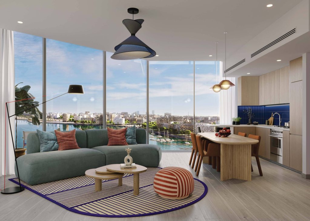 Salon moderne dans une villa de Dubaï avec un canapé bleu sarcelle, une table ronde en bois et des oreillers colorés. De grandes fenêtres offrent une vue sur la ville. Il y a une cuisine bleue en arrière-plan et un tapis coloré