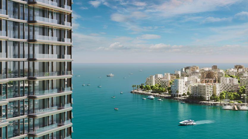 Un appartement moderne de grande hauteur surplombant une ville côtière avec une verdure luxuriante et de multiples bateaux dans la mer bleue sous un ciel clair.