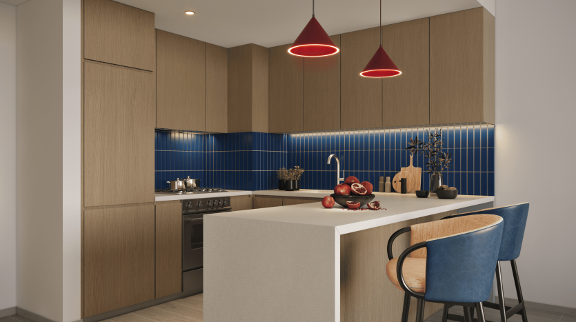 Une cuisine moderne avec des armoires en bois, un dosseret en carrelage bleu et un comptoir blanc. L&#039;espace est mis en valeur par des suspensions rouges au-dessus d&#039;un bar avec deux tabourets bleus, parfaits pour un investissement immobilier.