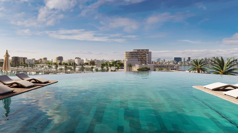 Piscine à débordement luxueuse avec vue sur les toits de la ville moderne de Dubaï, avec chaises longues et palmiers sous un ciel bleu clair.